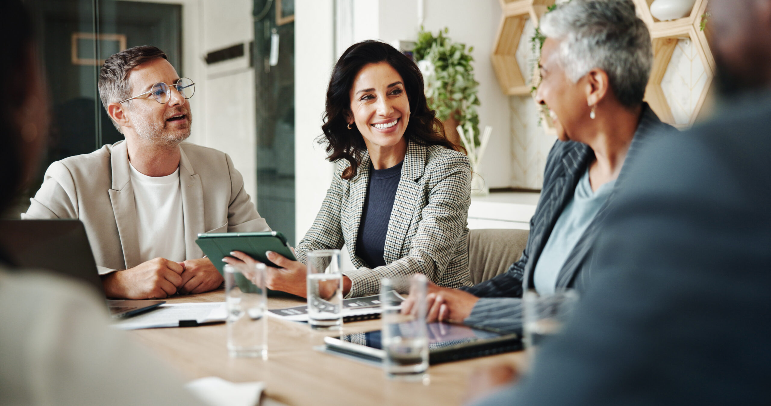 Teammeeting in der Verwaltung mit Tablet und Unterlagen zeigt digitale Zusammenarbeit und sichere Prozesse im öffentlichen Sektor.