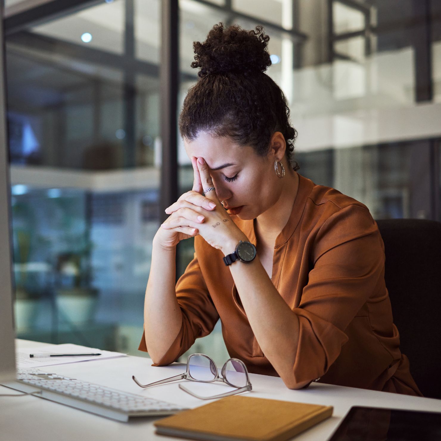 Gestresste Mitarbeiterin am Laptop warnt vor Quishing: QR-Code als Einfallstor für Cyberangriffe.