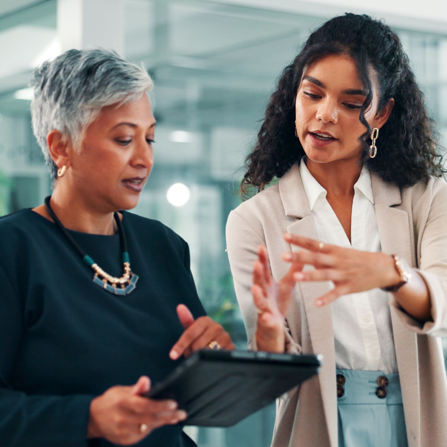 Zwei Mitarbeiterinnen besprechen am Tablet Maßnahmen für Notfallmanagement, Krisenmanagement und Business Continuity im Unternehmen.