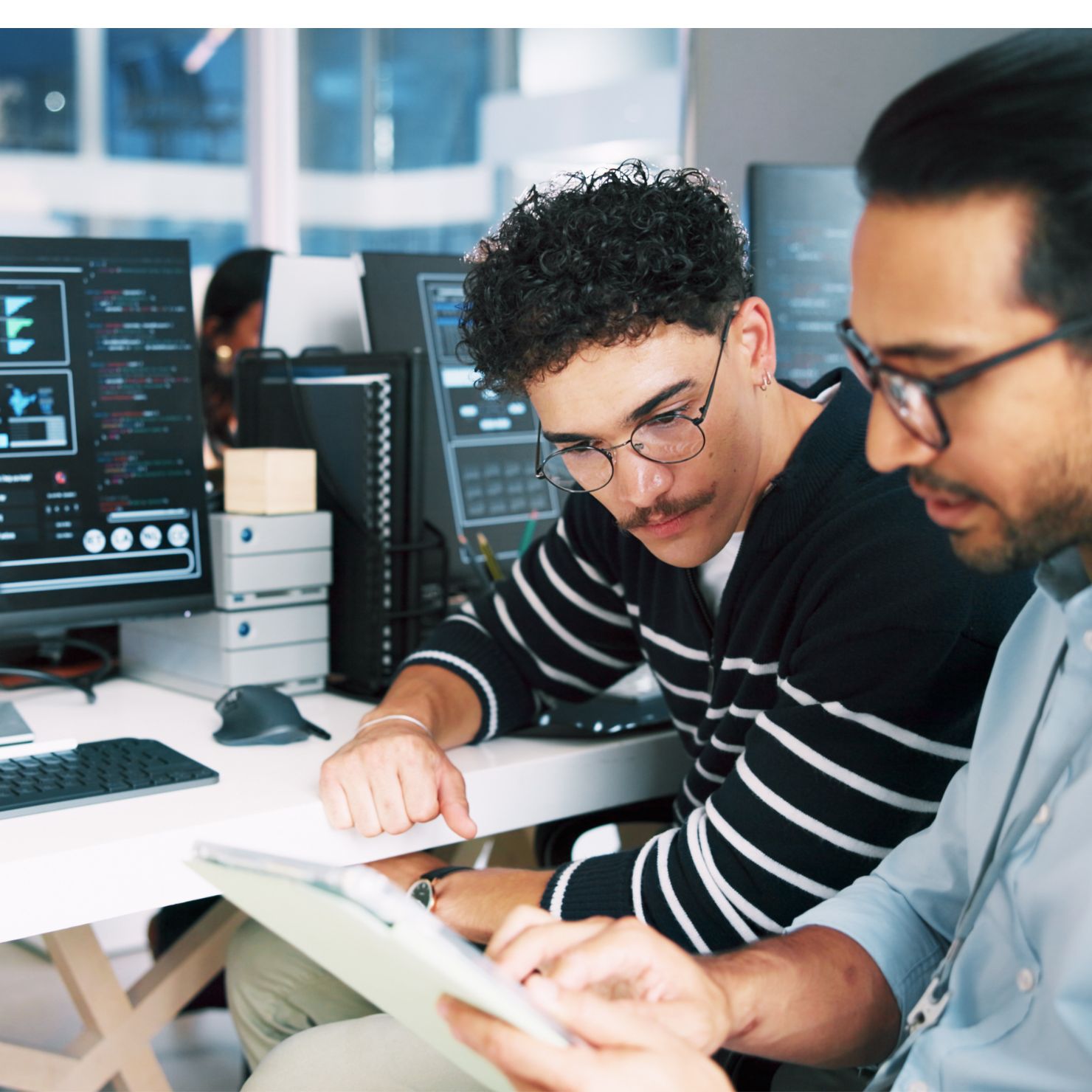 IT-Team analysiert Botnet-Code am Monitor und Tablet, passend zu Operation Endgame gegen weltweite Cyberkriminalität.