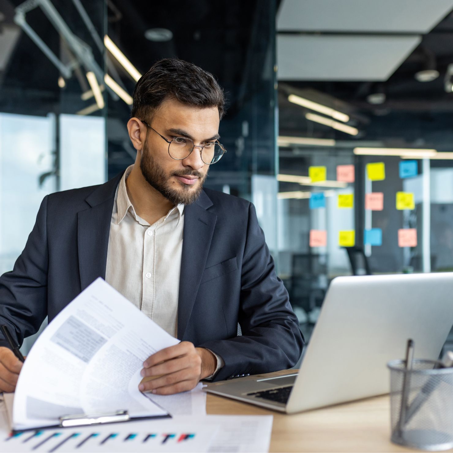 Berater prüft Unterlagen am Laptop zur NIS2-Beratung, Compliance und IT-Sicherheitsstrategie im Unternehmen.