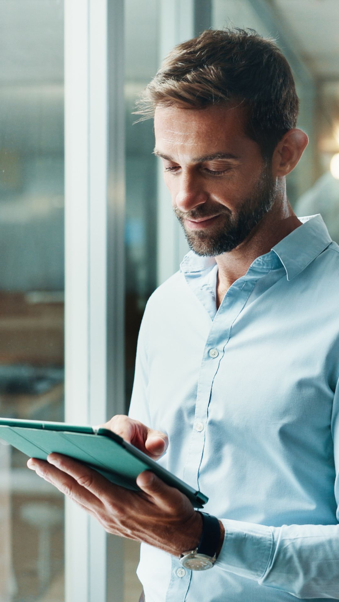 Ein Mitarbeiter prüft auf einem Tablet die Sicherheit und volle Transparenz aller Endgeräte im Unternehmensnetzwerk.