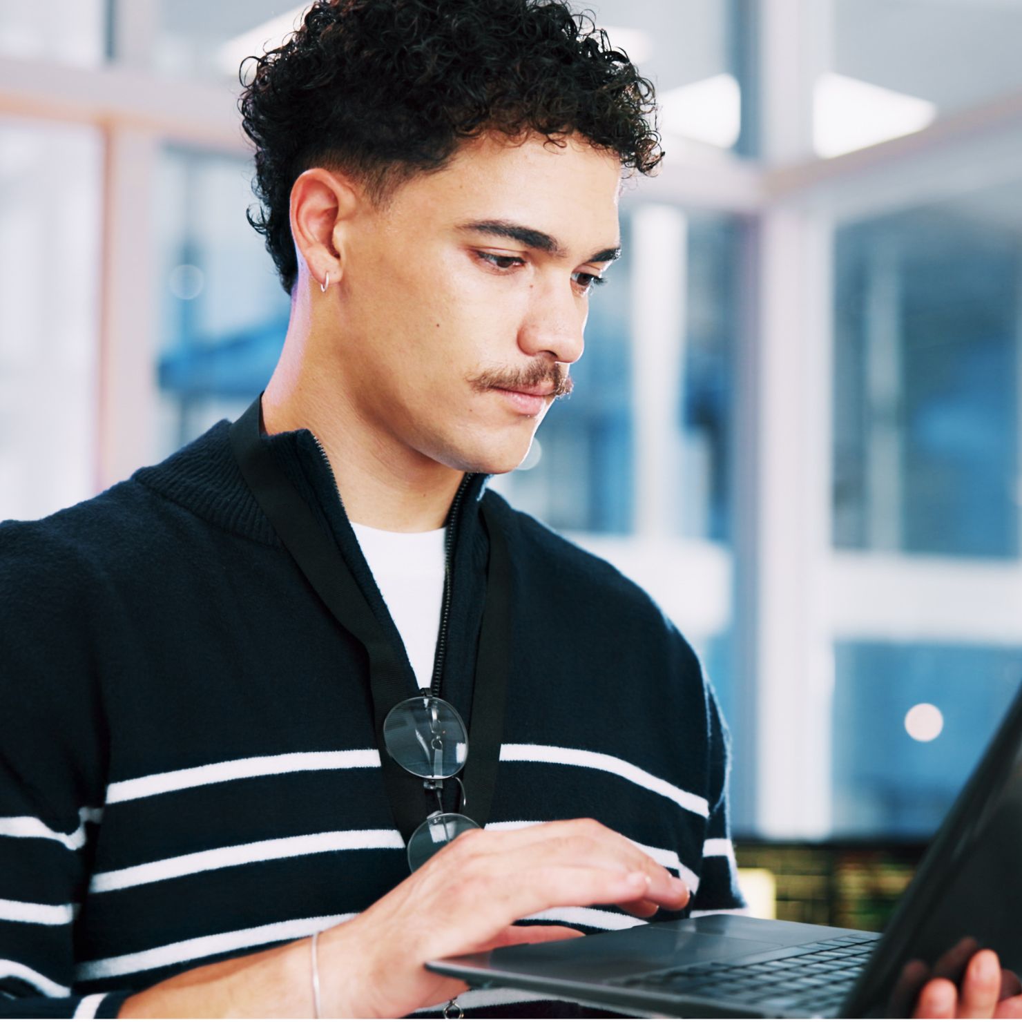 Mann arbeitet am Laptop und zeigt Cyber Security für KMU, die zunehmend Ziel von Cyberangriffen sind.