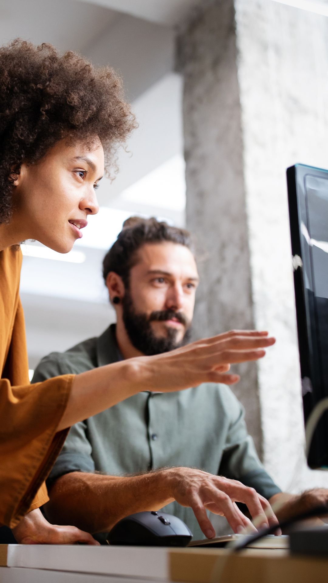 Zwei IT-Sicherheitsexperten analysieren gemeinsam am Monitor ausgelagerte Security-Prozesse, minimieren Risiken und sichern die Verfügbarkeit der Systeme.