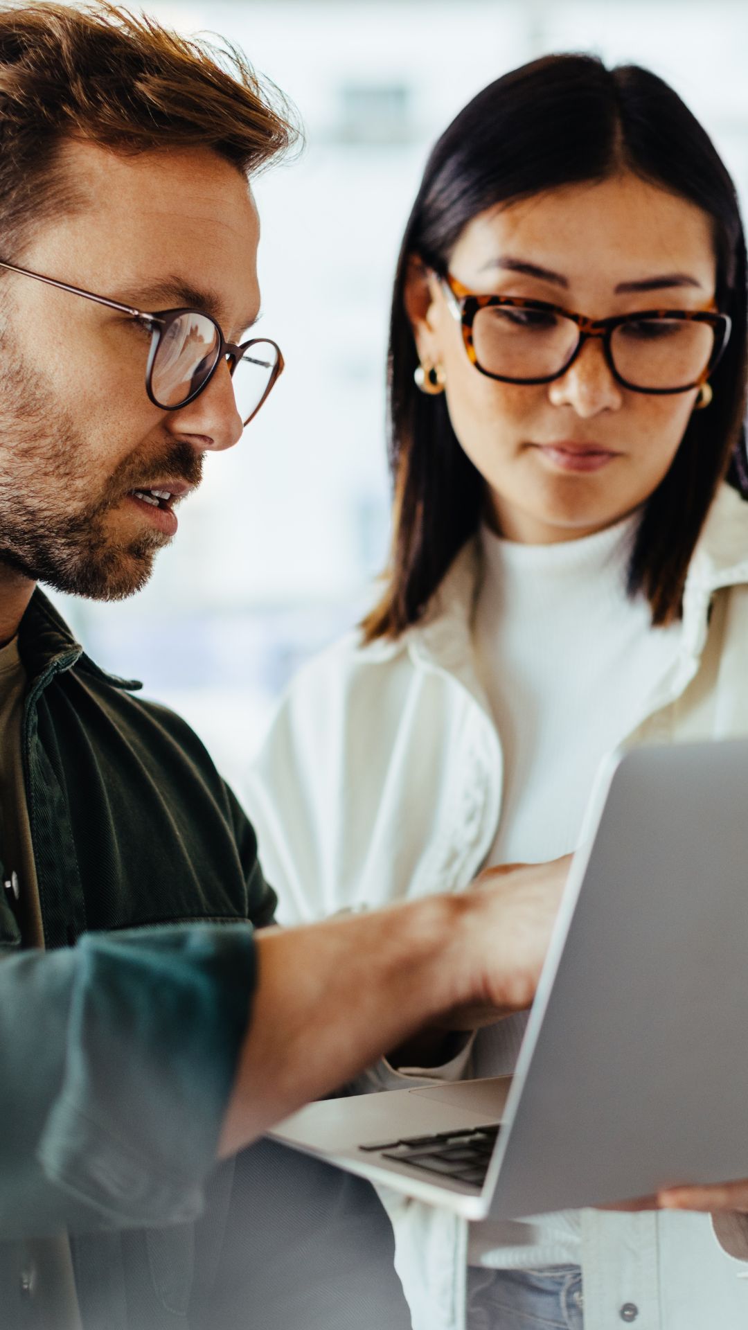Zwei Mitarbeitende setzen Vorgaben und Compliance-Anforderungen gemeinsam effizient in einem zentralen Management-Tool am Laptop um.