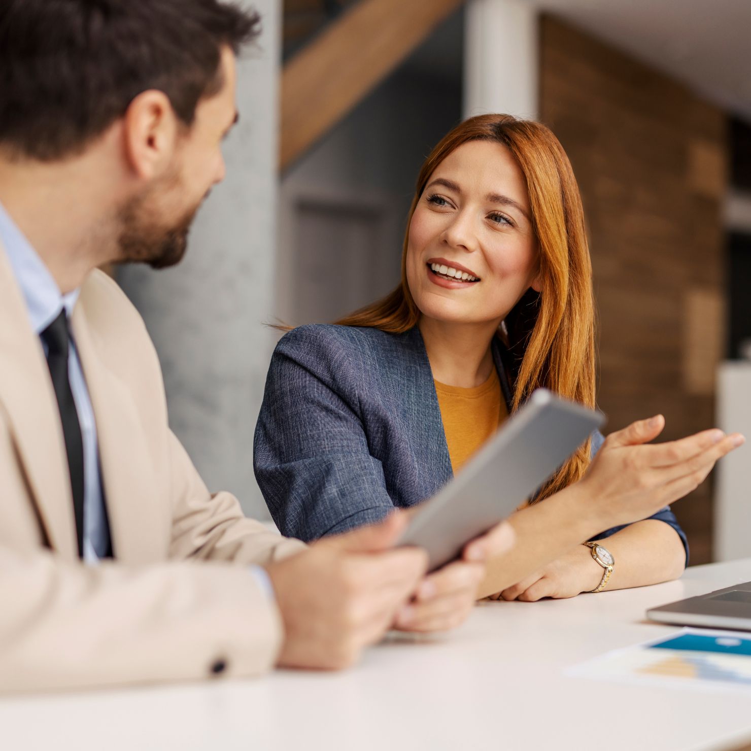 Business-Gespräch mit Tablet im Büro: Eine Frau erklärt einem Kollegen Inhalte auf einem Tablet – passendes Bild für den JULIA mailoffice modular Produktflyer.