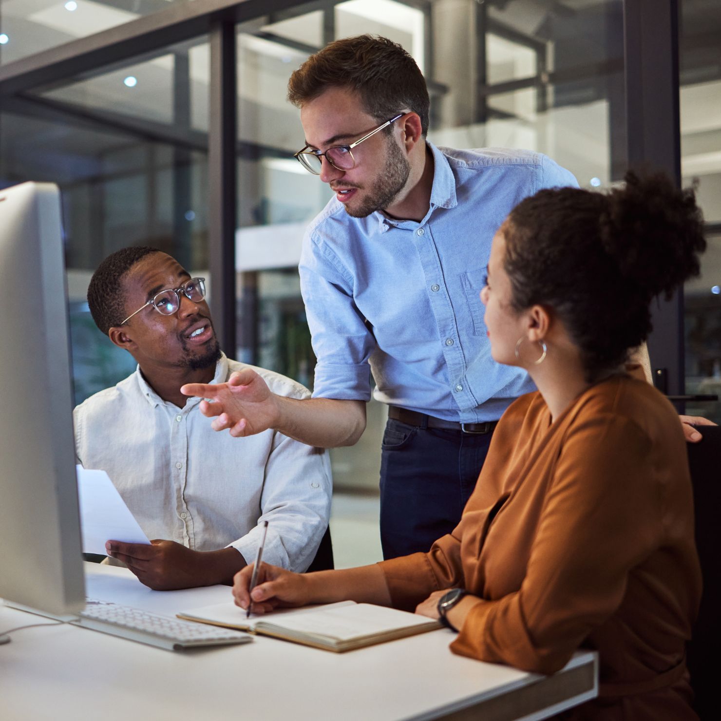 Ein IT-Sicherheitsteam bespricht gemeinsam am Computer Cybersecurity-Strategien, Sicherheitsanalysen und operative Maßnahmen im Unternehmen.