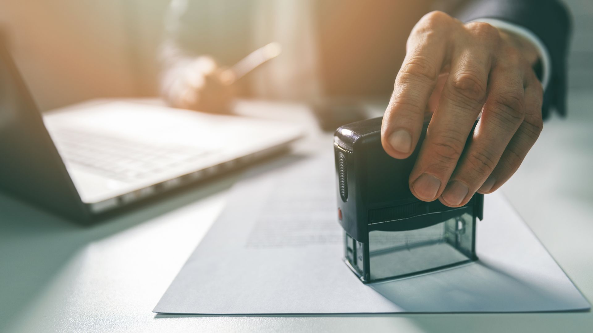Stempel auf einem Dokument im Büro symbolisiert Dokumentenprüfung, Freigabeprozesse und IT-Sicherheit im öffentlichen Sektor.