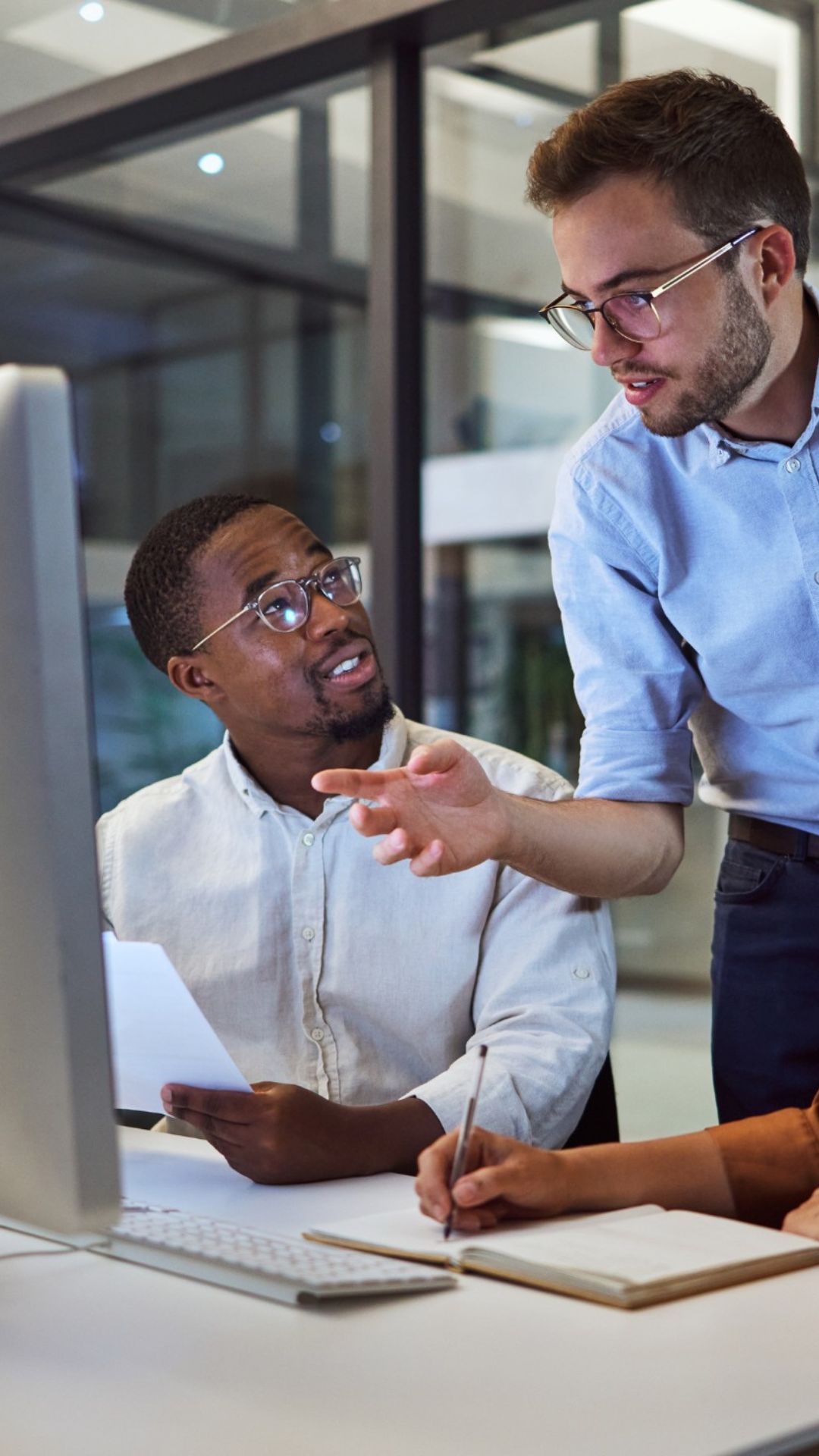 Das IT-Team von Kellner Telecom bespricht am Monitor, wie mit Active Cyber Defense (ACD) der Aufwand reduziert und der Schutz vor Cyberangriffen erhöht wird.